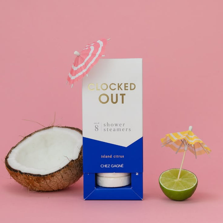 Box of 'Clocked Out' shower steamers with a half-coconut and lime on a pink background