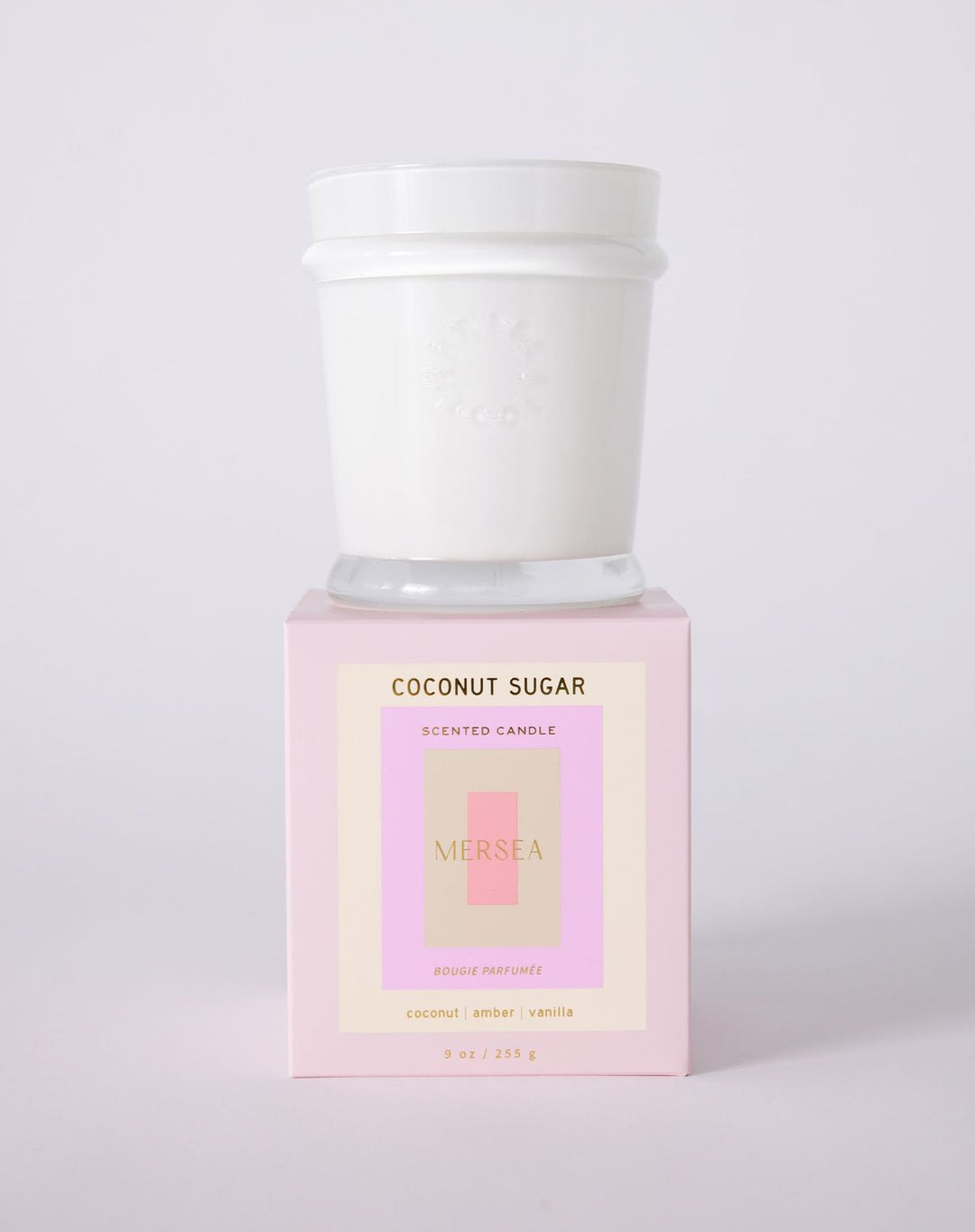 Scented candle labeled 'Coconut Sugar' by Neshea on a light pink background