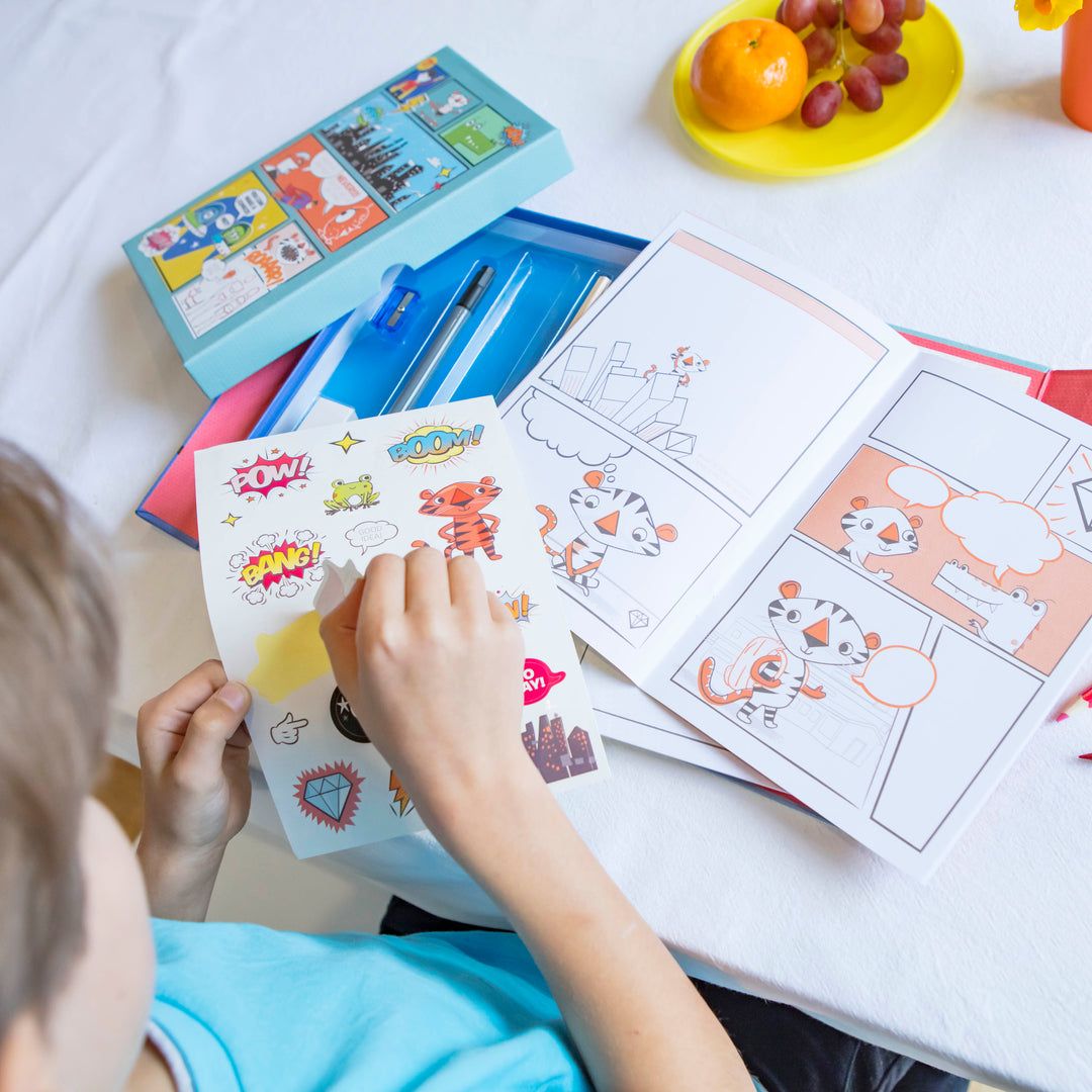 Child coloring with crayons and coloring books on a table.