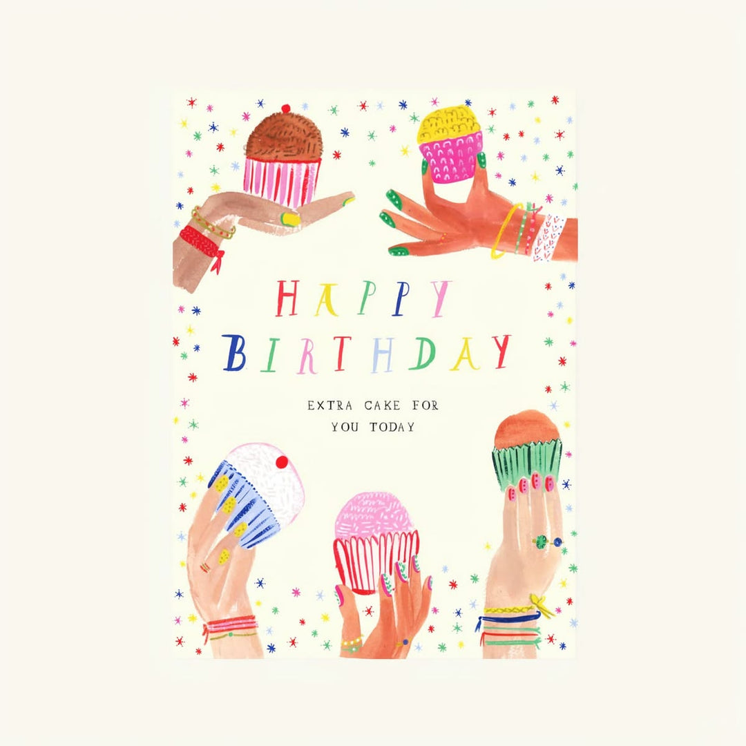 A colorful birthday card design featuring the text 'HAPPY BIRTHDAY' in multicolored letters, with illustrations of hands holding cupcakes around the border on a light cream background.