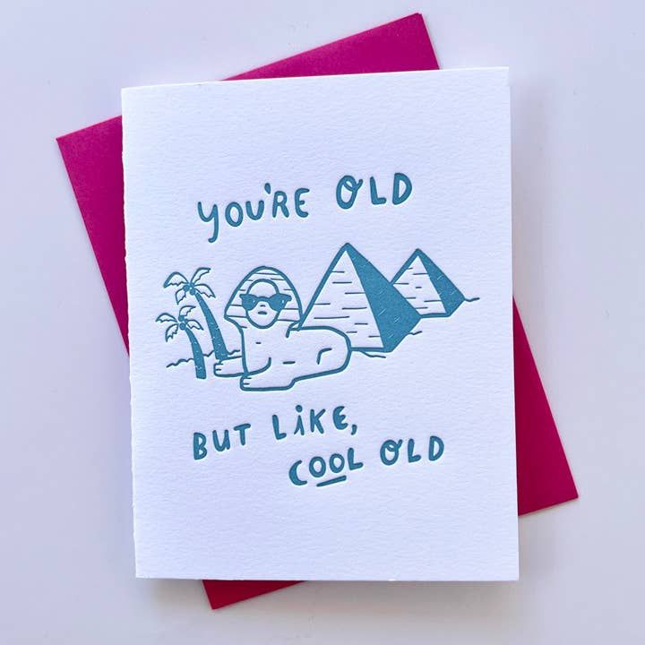 Greeting card with Sphinx and pyramids illustration and text 'You're old but like, cool old' on a white background.