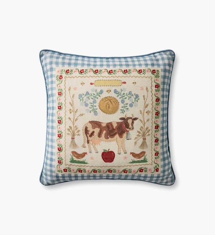 Decorative pillow with a cow and farm-themed embroidery on a blue checkered background