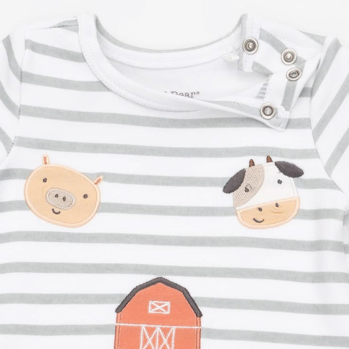 A close-up of a baby long-sleeve top with gray and white horizontal stripes, featuring embroidered farm animal faces including a pig, cow, and barn.