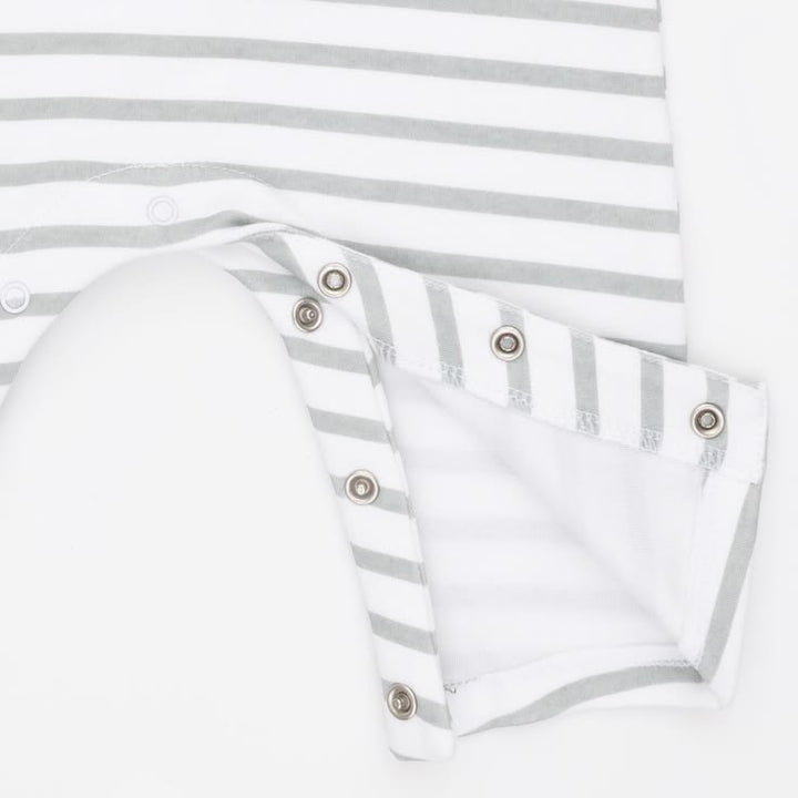 Close-up of a white and light gray striped baby garment with a folded sleeve or cuff showing metal snap buttons on a white background.