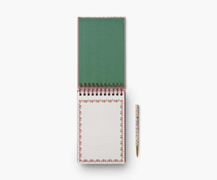 Green notepad with a pen on a white background