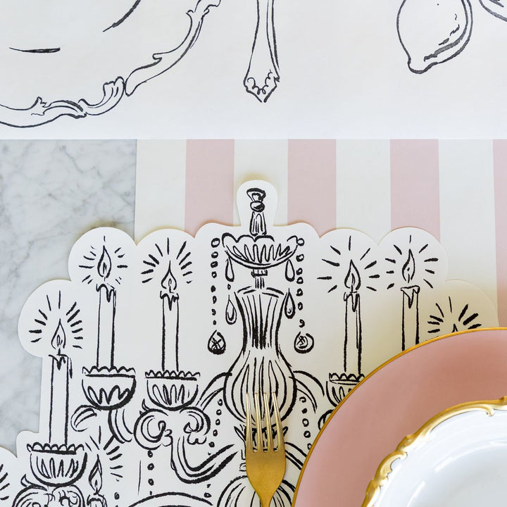 Decorative placemat with candle and chandelier design on a marble surface.