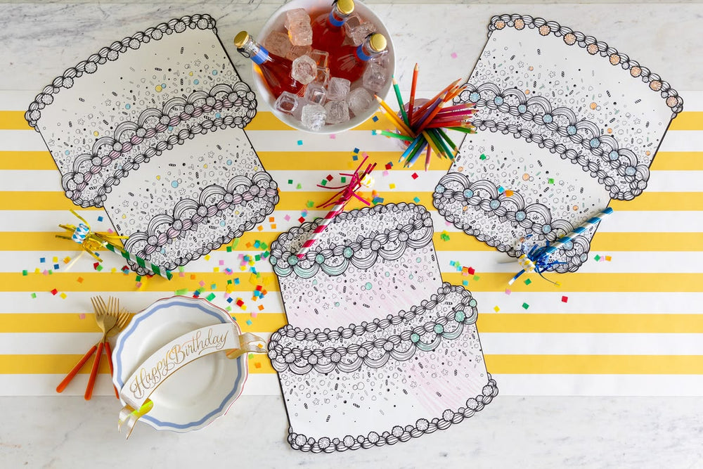 Coloring placemats on a table with birthday-themed items