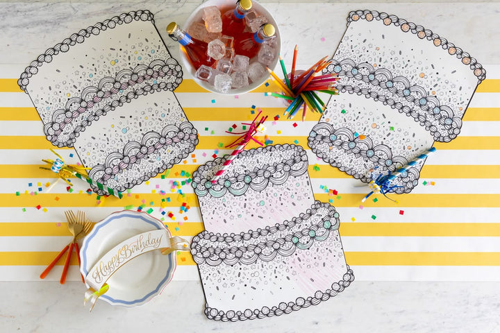 Coloring placemats on a table with birthday-themed items