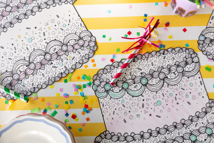 Coloring books with intricate patterns on a yellow surface with confetti