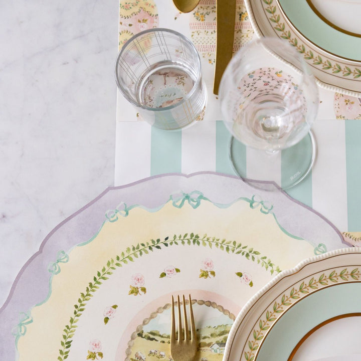 Pastel-colored table setting with floral patterns on plates and glasses.