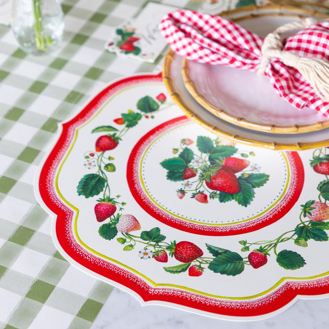 Decorative plate with strawberry design on a checkered tablecloth