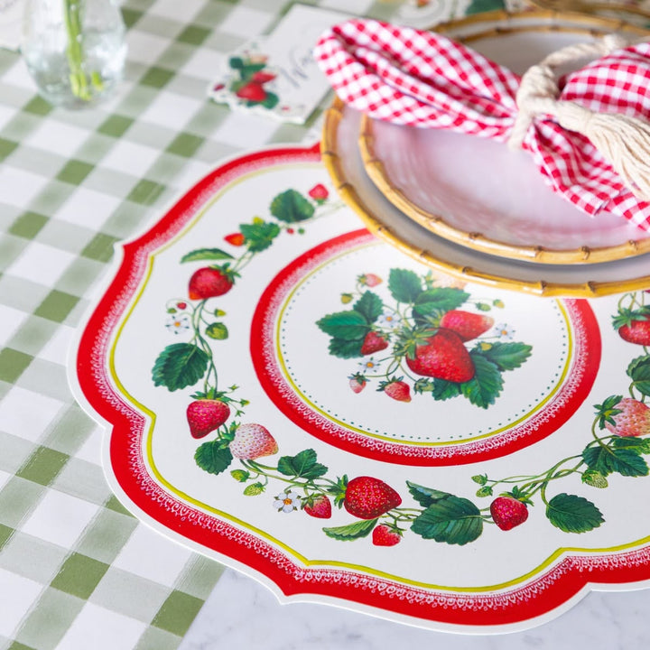 Decorative plate with strawberry design on a checkered tablecloth