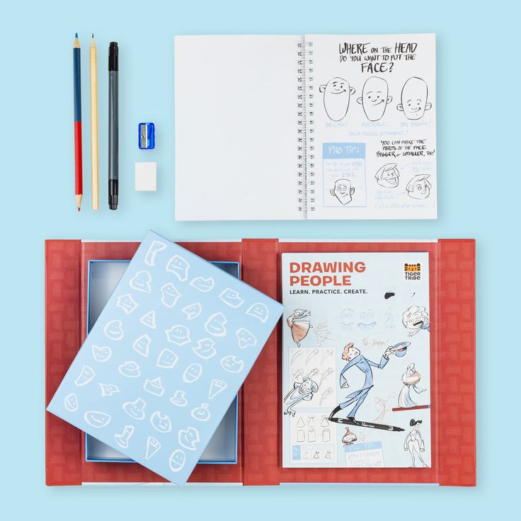 Art supplies including a notebook, stickers, and drawing guides on a blue background