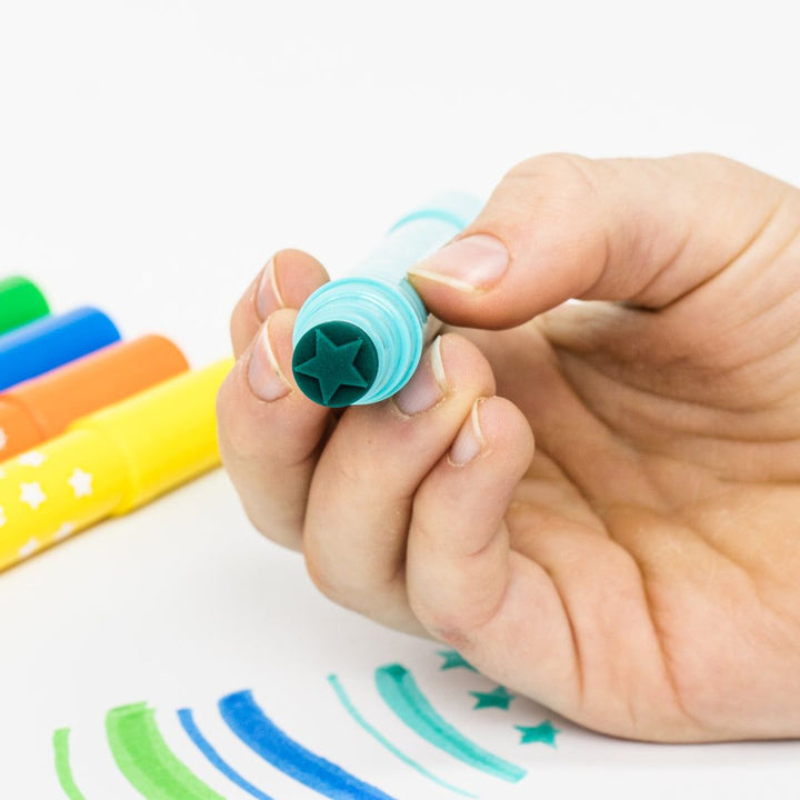 Hand holding a colorful marker with a white background