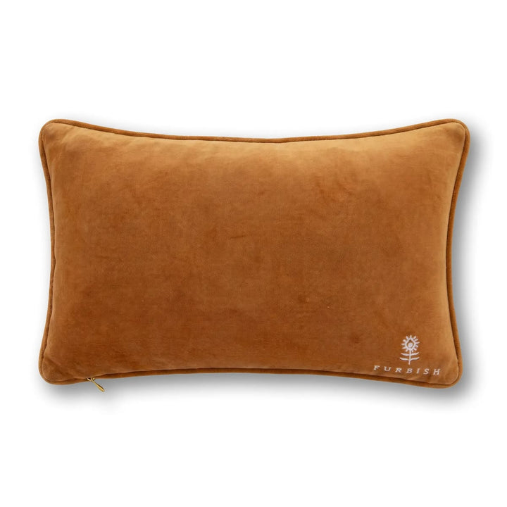A rectangular lumbar pillow in a warm camel brown velvet fabric, featuring a small white embroidered 'FURNISH' brand logo in the bottom right corner, set against a plain white background.
