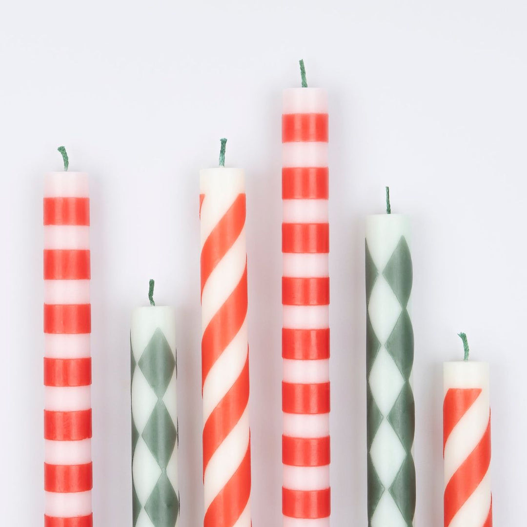Set of colorful striped candles on a light gray background