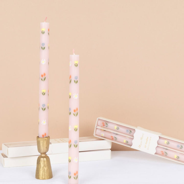 Tall pink candles with floral patterns on a beige background