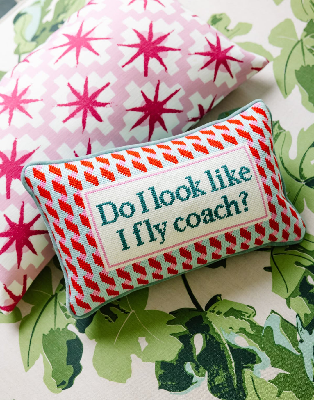 Decorative pillow with text 'Do I look like I fly coach?' on a floral background