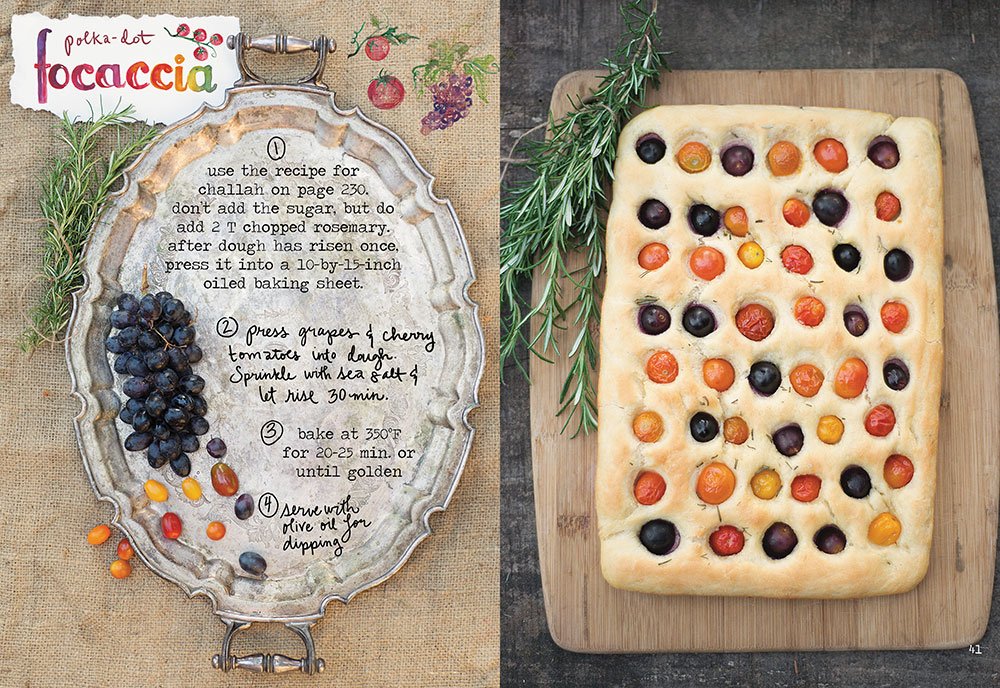 Focaccia bread with olives and tomatoes on a wooden board, accompanied by a recipe card.