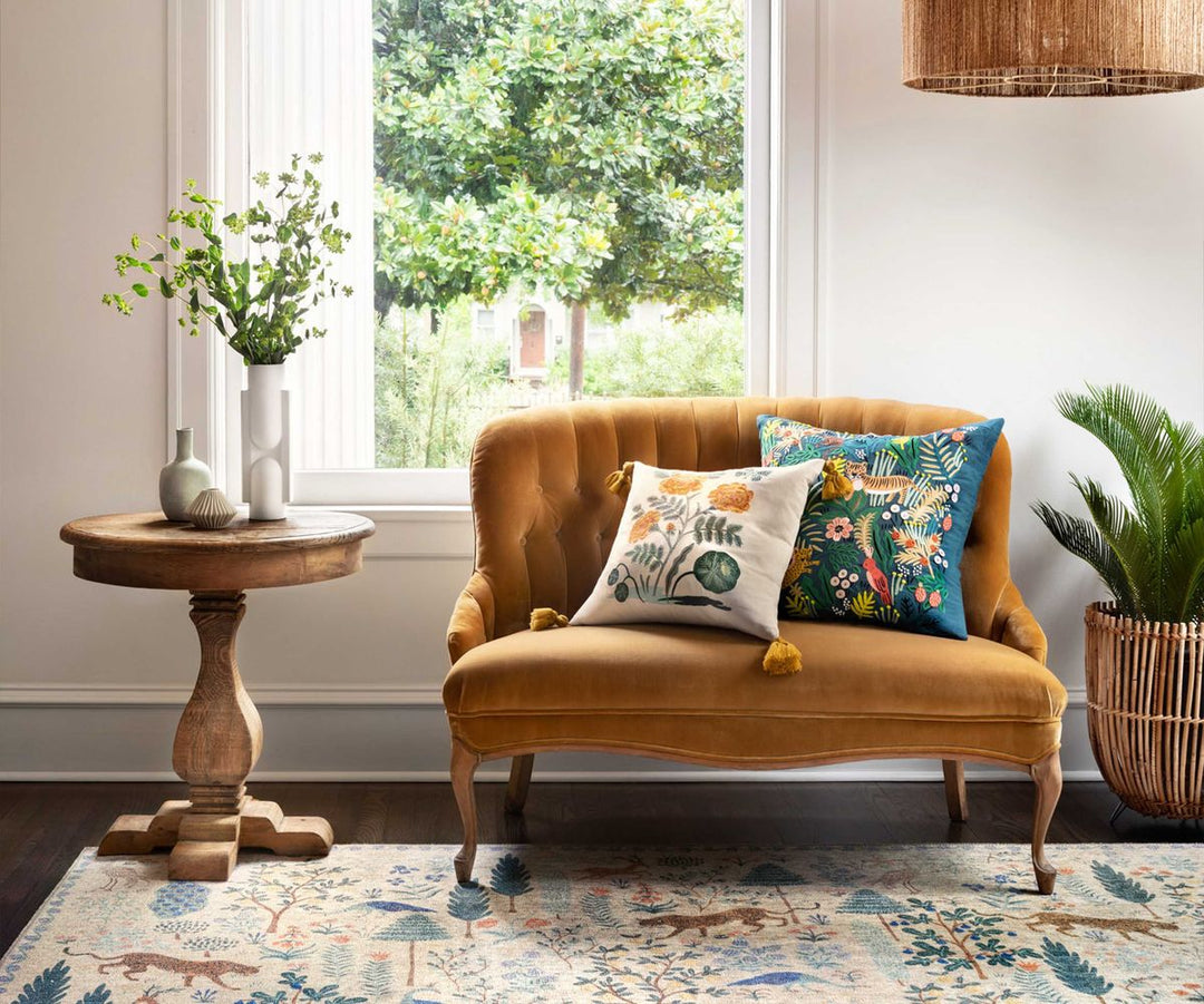 Yellow velvet sofa with floral cushions in a bright living room