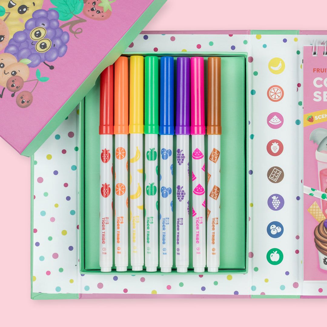 Set of colorful markers in a polka dot box with a pink background