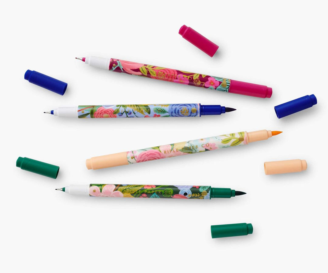 Colorful markers with floral designs on a white background