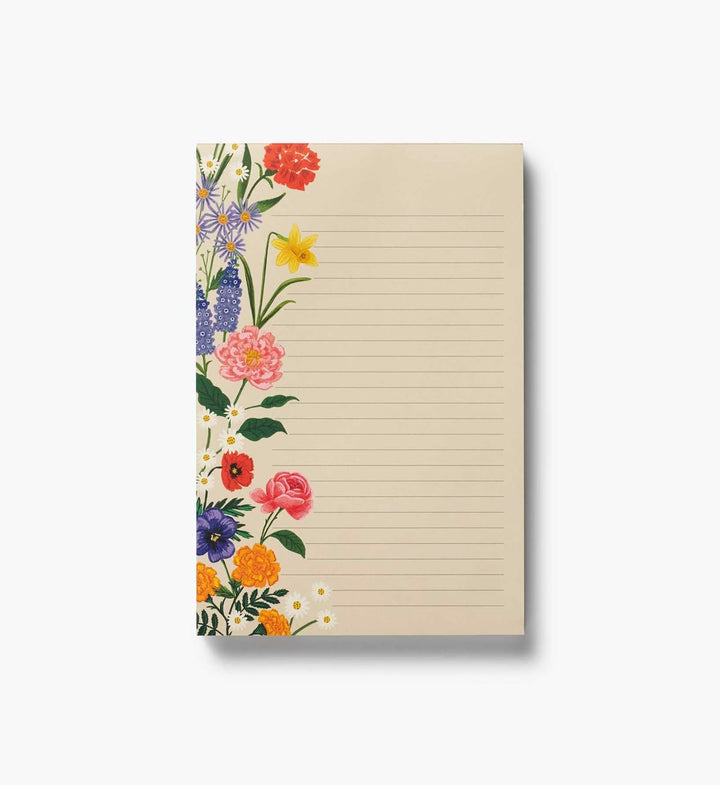A lined notepad with a cream-colored page and a floral border design on the left side, featuring red, pink, yellow, orange, and purple flowers with green leaves, shown on a light gray background.