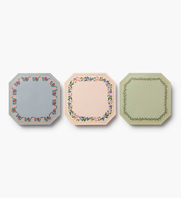 Three decorative notepads with floral patterns on a white background
