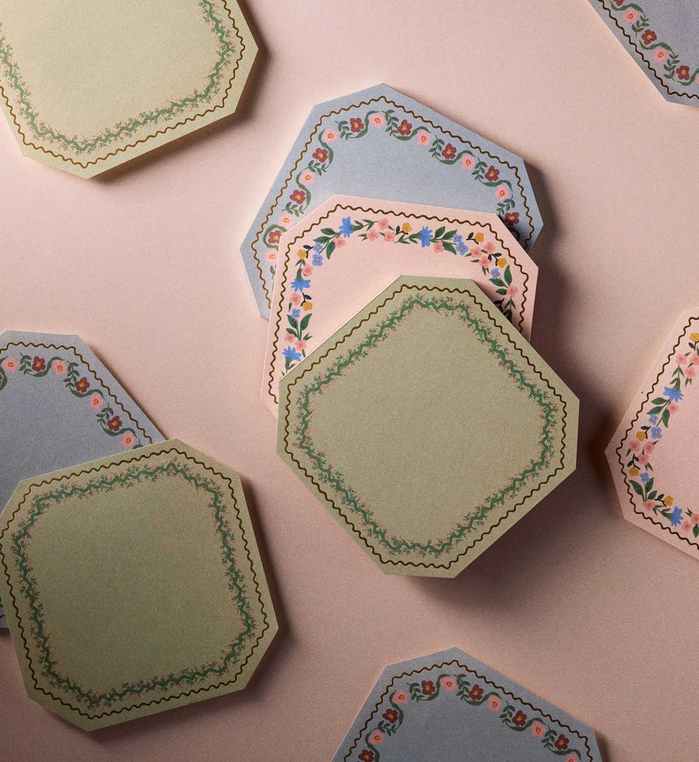 Hexagonal paper coasters with floral patterns on a pink background