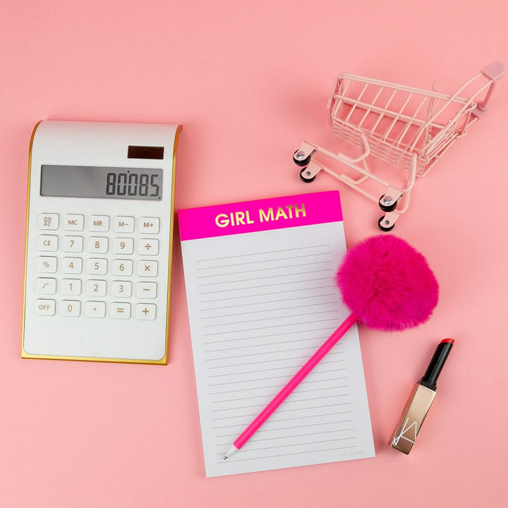 Calculator, notepad, pink pen, small shopping cart, and lip gloss on a pink background