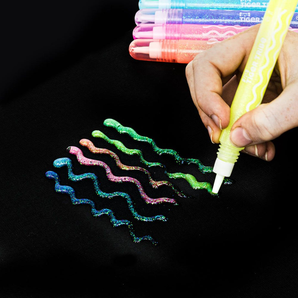 Colorful wavy lines drawn on a black surface with a yellow marker.