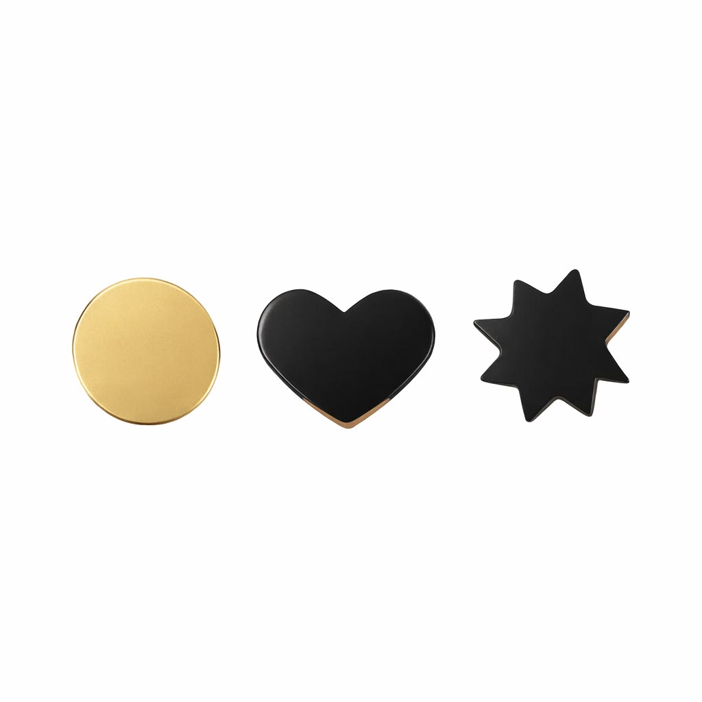 Three decorative pins with gold circle, black heart, and black star design on a white background