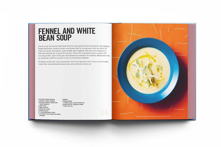 An open cookbook spread showing a recipe for Fennel and White Bean Soup. The left page has the recipe text under a bold title, and the right page features a top-down photo of the soup in a blue bowl against an orange background.