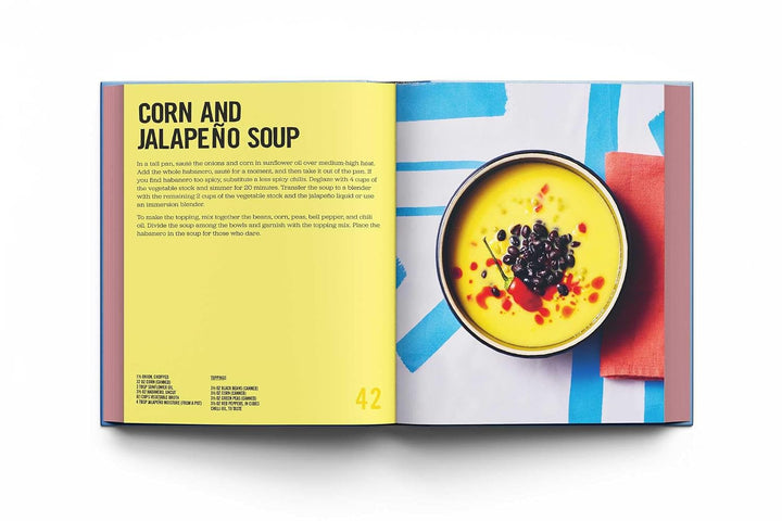 Open cookbook showing a recipe for corn and jalapeño soup with a colorful layout.