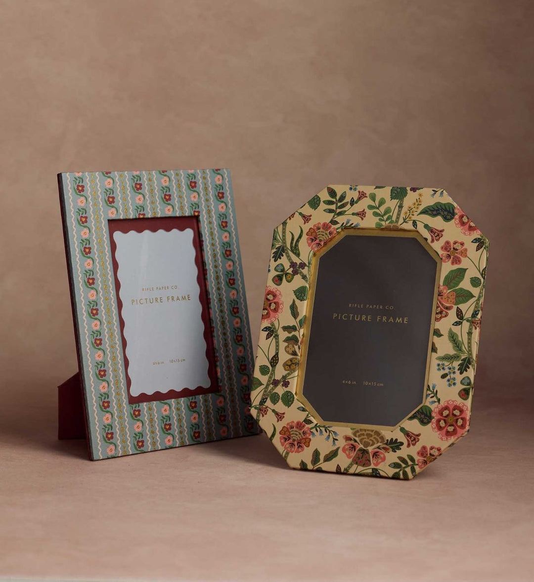 Two decorative picture frames with floral designs on a brown background