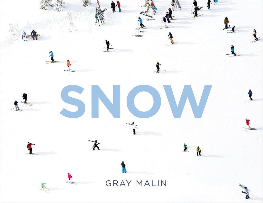 A square book cover titled "SNOW" by Gray Malin, featuring a snowy mountain scene with many small skiers and snowboarders scattered across the white snow.