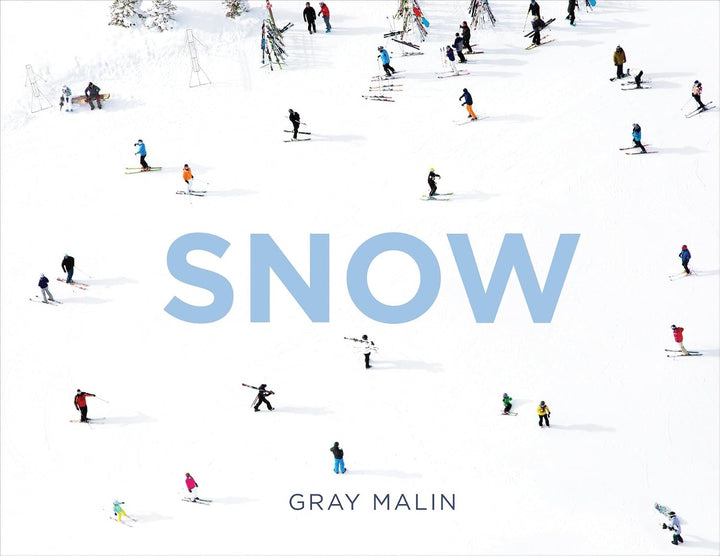 A square book cover titled "SNOW" by Gray Malin, featuring a snowy mountain scene with many small skiers and snowboarders scattered across the white snow.