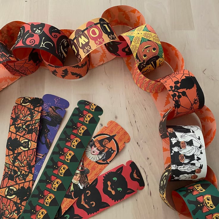Halloween-themed paper chains with various designs on a wooden surface.