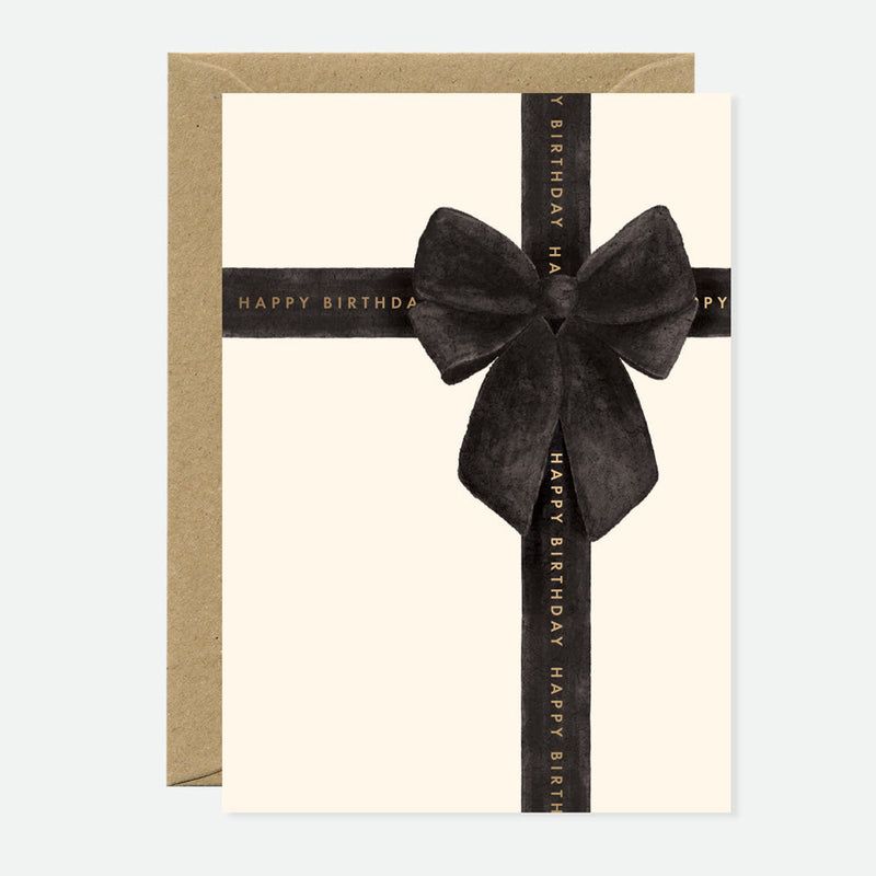 Greeting card with a black ribbon and bow on a beige background