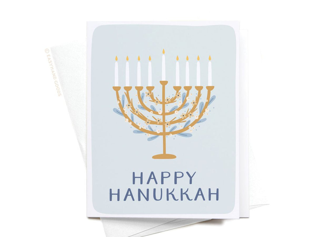 Greeting card with Menorah design and 'Happy Hanukkah' text on a light blue background