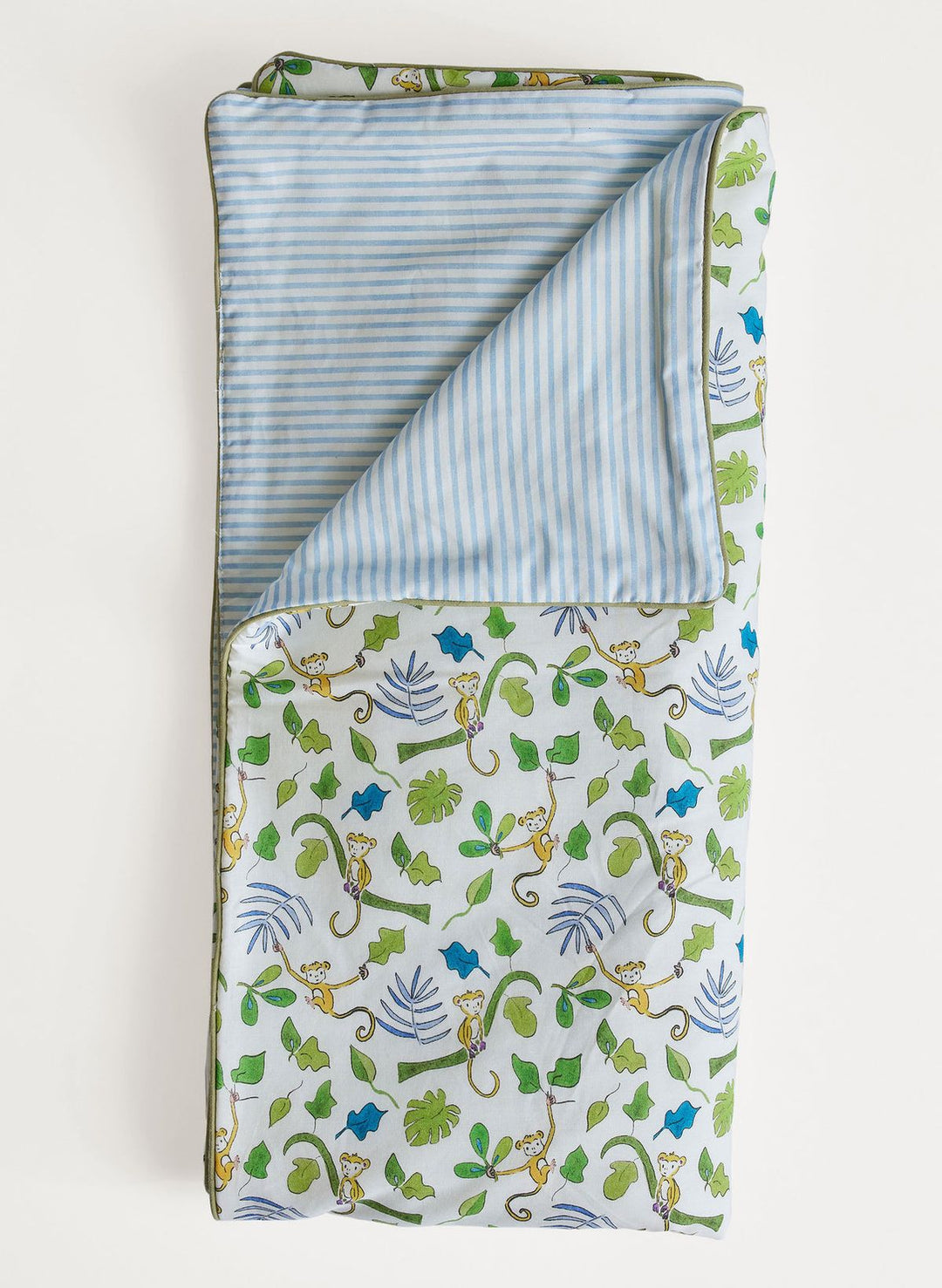 Folded blanket with animal and leaf pattern on a white background