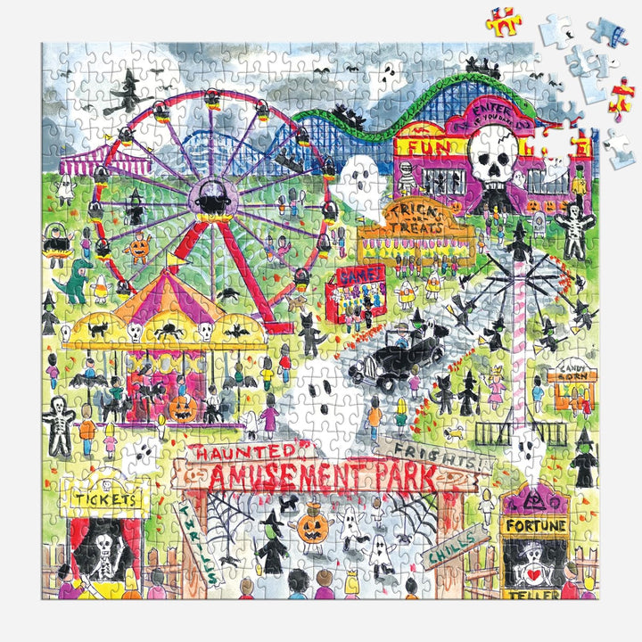 A completed jigsaw puzzle featuring a whimsical Halloween amusement park scene with a ferris wheel, carnival tents, ghosts, skeletons, haunted-house signs, and playful illustrations. Several loose puzzle pieces are scattered around the edges on a white background.