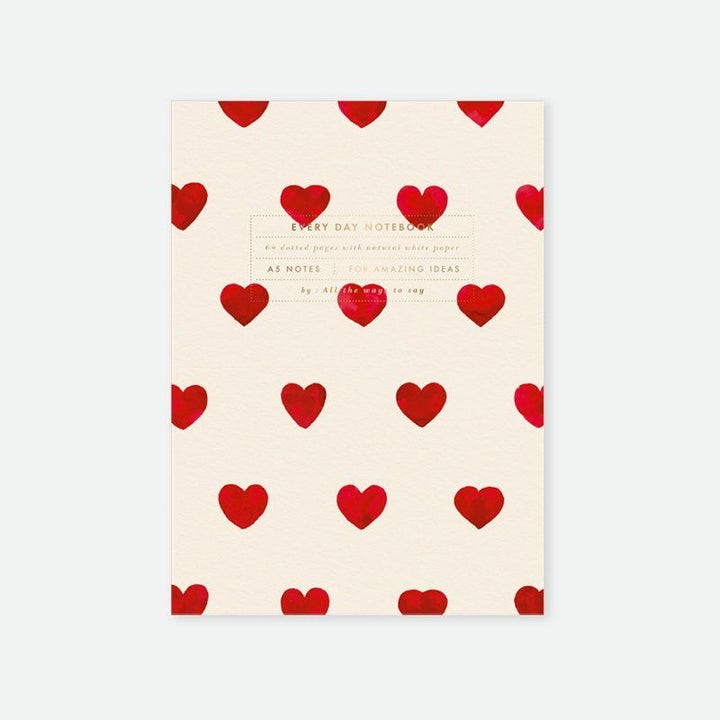 Notebook with red heart pattern on a beige background
