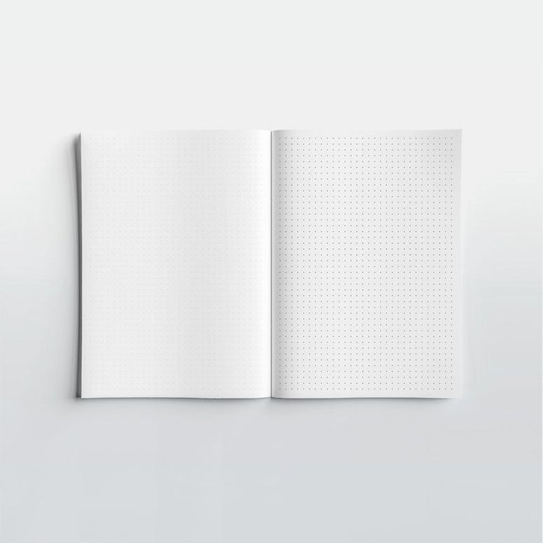 Open notebook with grid and plain pages on a light gray background