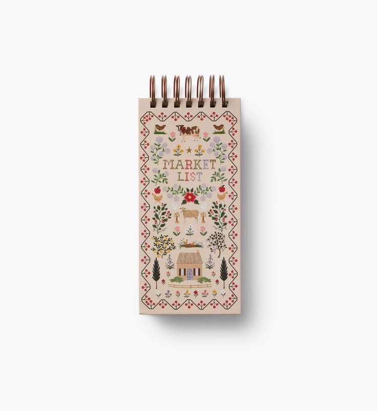 Small spiral-bound notebook with decorative cover on a white background