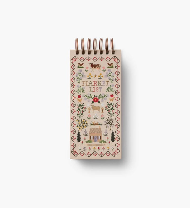 Small spiral-bound notebook with decorative cover on a white background