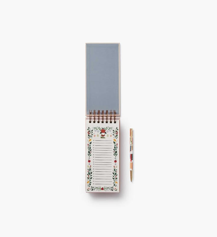 Notepad with floral design and pen on a white background