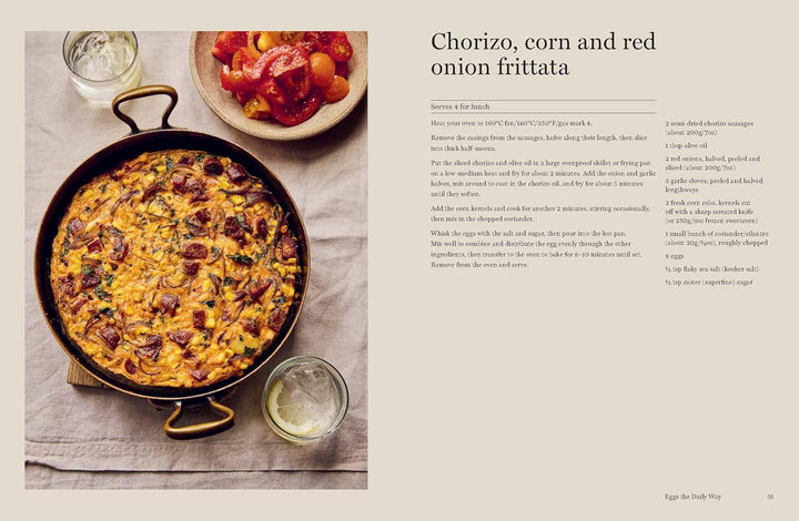 Frittata with chorizo, corn, and red onions in a pan on a tablecloth with a glass of white wine.
