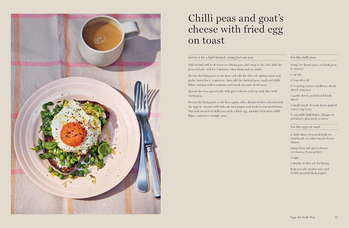 Plate of food with a fried egg, peas, and goat's cheese on toast, accompanied by a cup of tea on a checkered tablecloth.