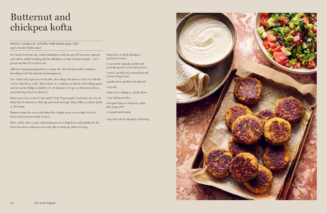 Butternut and chickpea kofta on a tray with a bowl of yogurt and salad in the background.